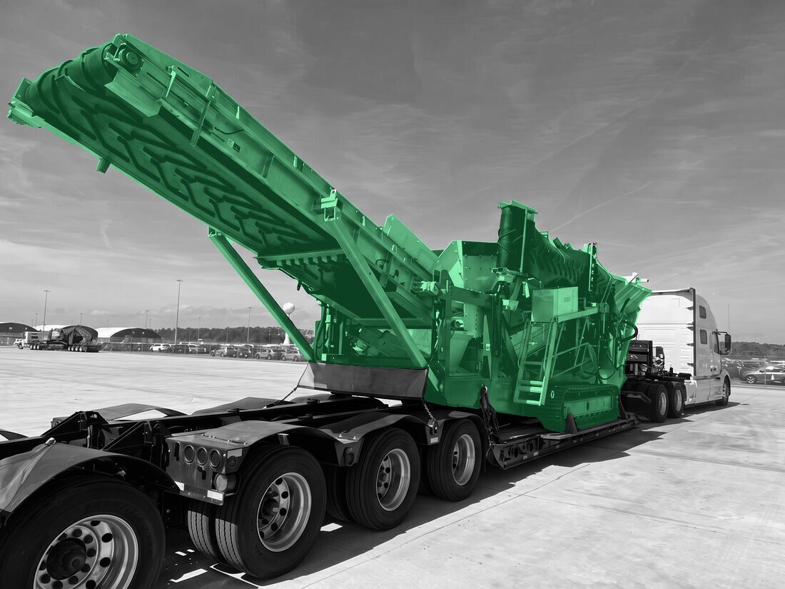 Tracked mobile screening plant with raised conveyor on OVERSIZE LOAD lowboy trailer