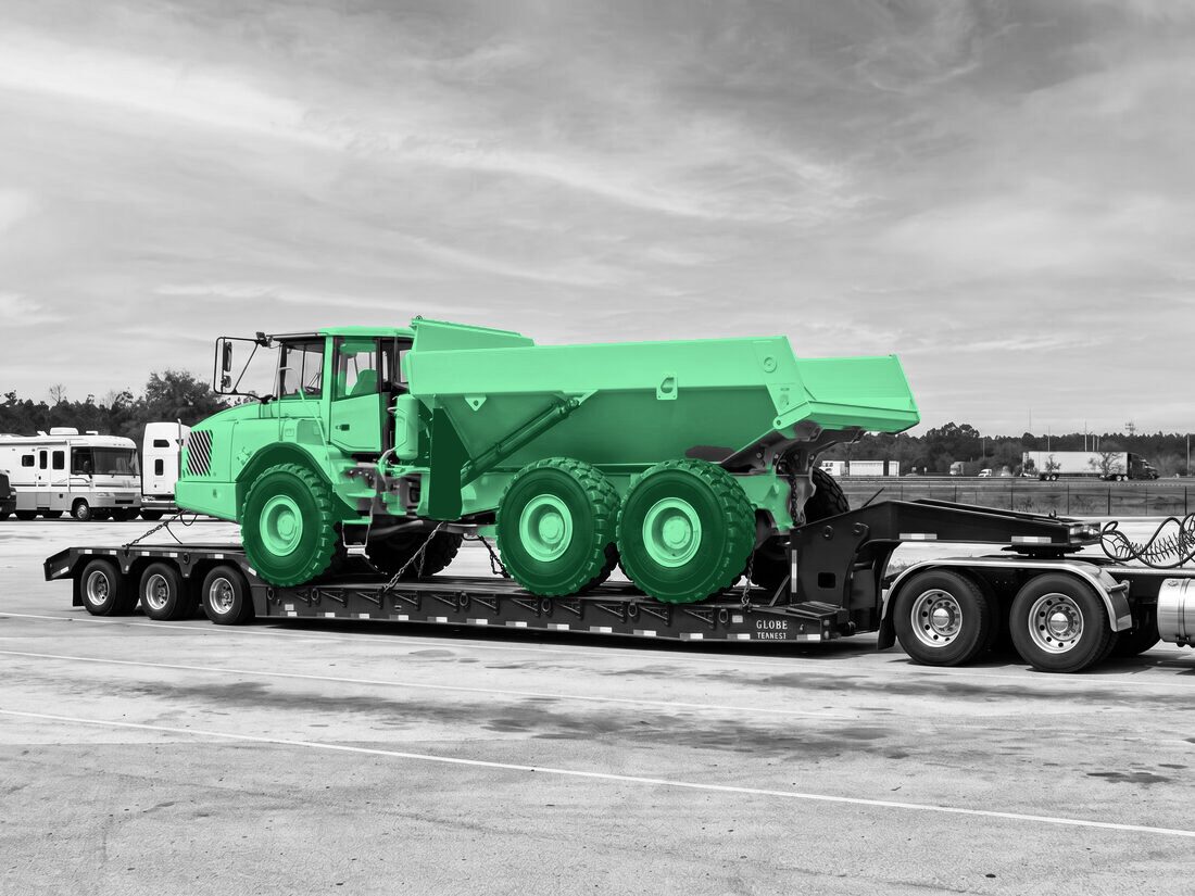 Yellow Volvo A30D articulated mining dump truck on Globe Trailers lowboy at rest stop