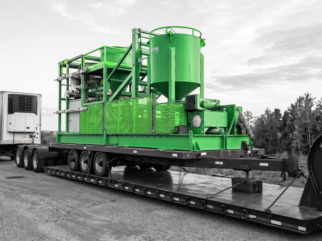 Metso skid-mounted hydraulic power unit and hopper on lowboy at dusk