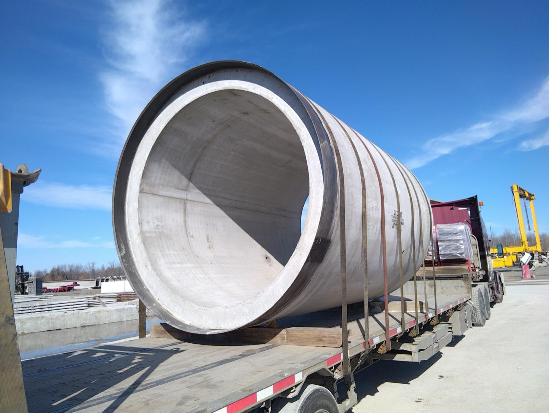 Large precast concrete pipe / culvert section on flatbed at precast yard