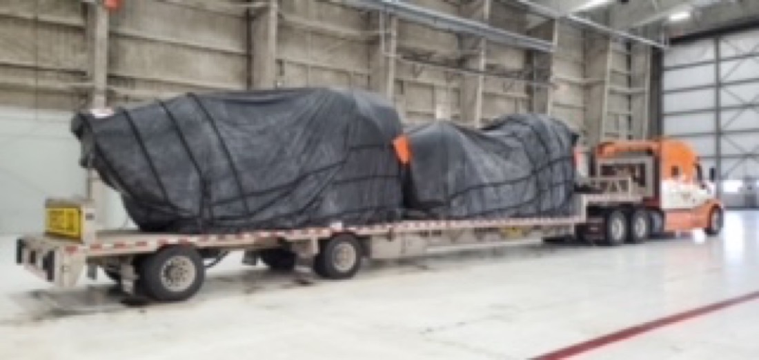 Same tarped cargo on flatbed — full side profile with Mack tractor hooked up