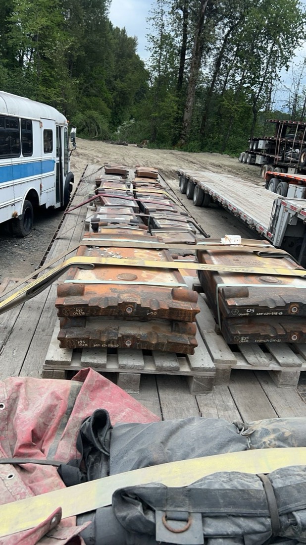 Rows of mill liner plates (mining wear parts) on pallets across stretch flatbed