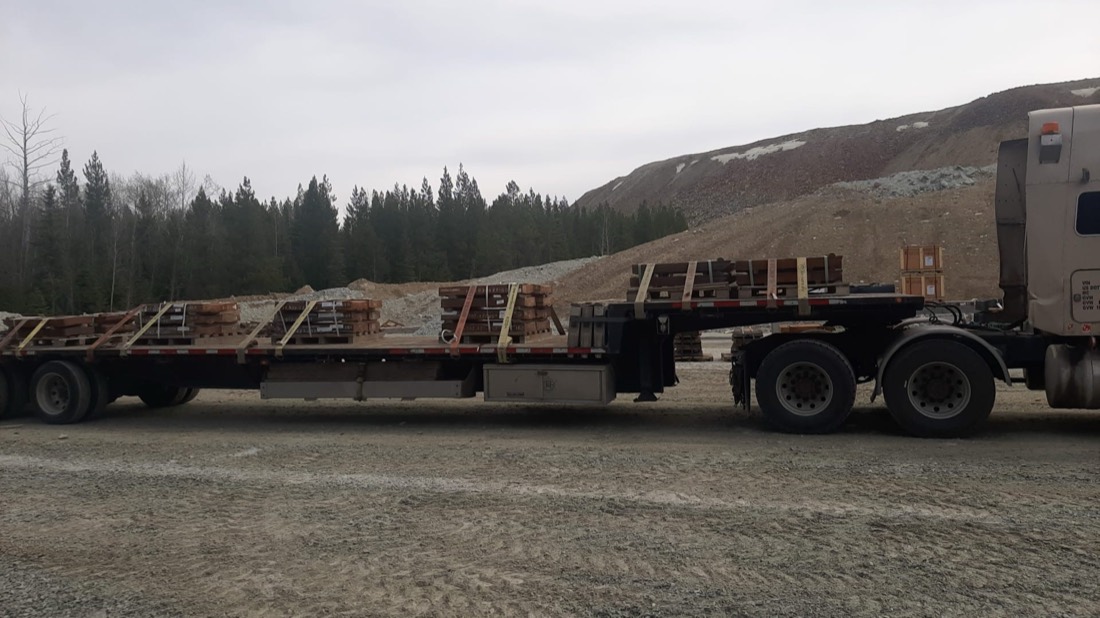 Mining wear parts / mill liners on wood pallets across flatbed at mine site