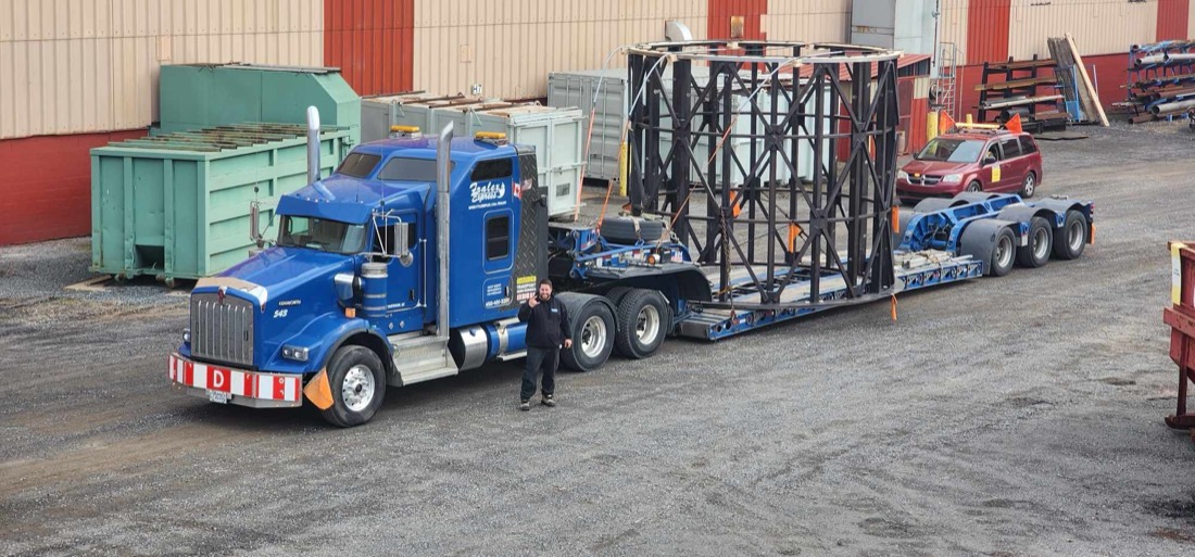 Blue Kenworth with cylindrical structural steel internal frame (furnace/reactor cage) on lowboy trailer