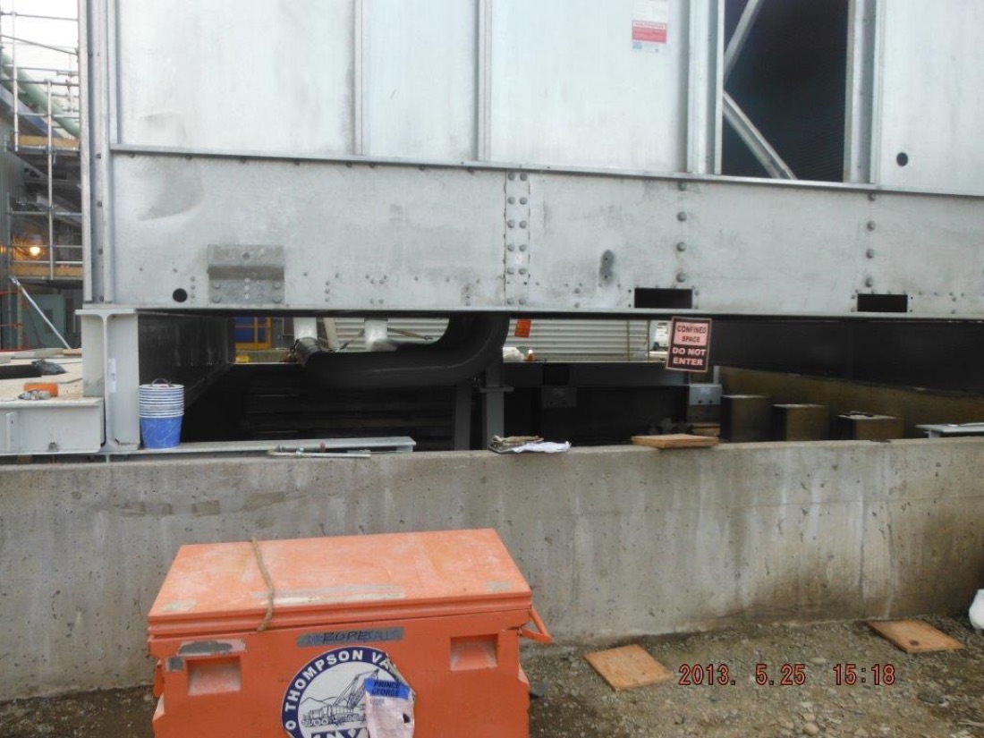 Close-up of installed cooling tower module showing mounting brackets and confined space warning