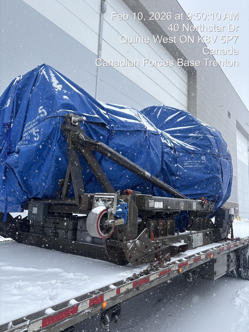 Blue-tarped jet engine on stand on flatbed at CFB Trenton (military airbase), snow