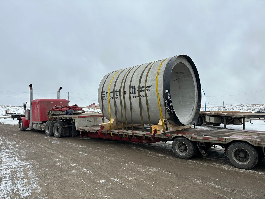 Erritt / Heidelberg precast concrete pipe on lowboy trailer pulled by red Peterbilt (winter)