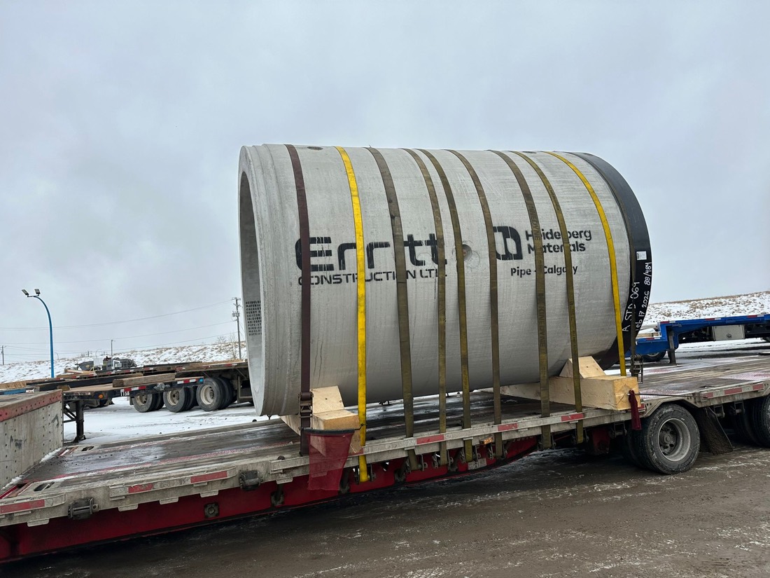 Erritt / Heidelberg precast concrete pipe strap-secured on lowboy trailer (Calgary)