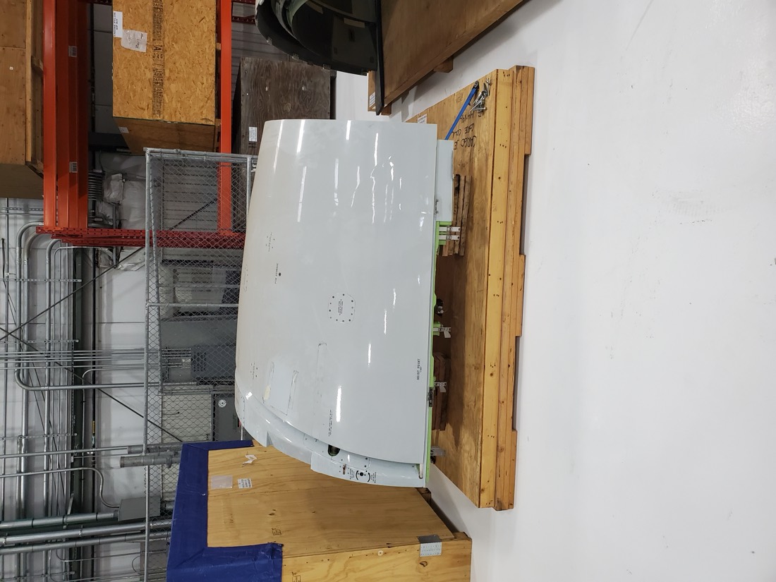 Aircraft cowling panel on wood shipping pallet in aerospace warehouse