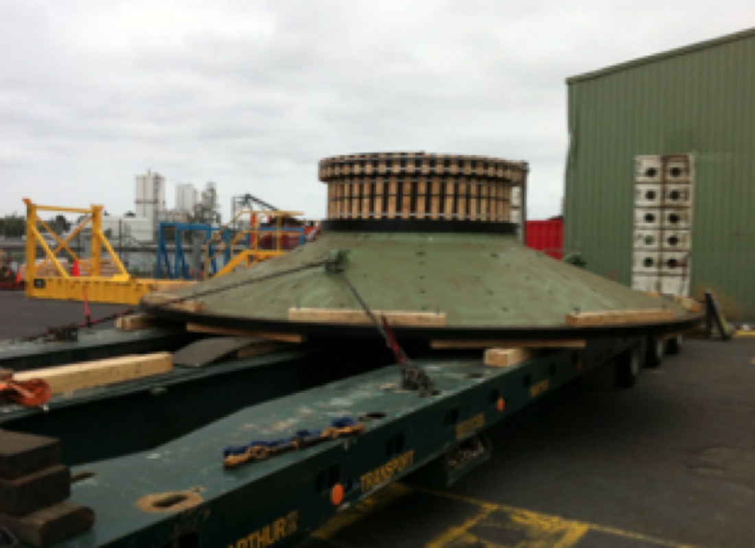 Green hydro turbine runner / industrial impeller on low-bed trailer at port (duplicate of 111.png)