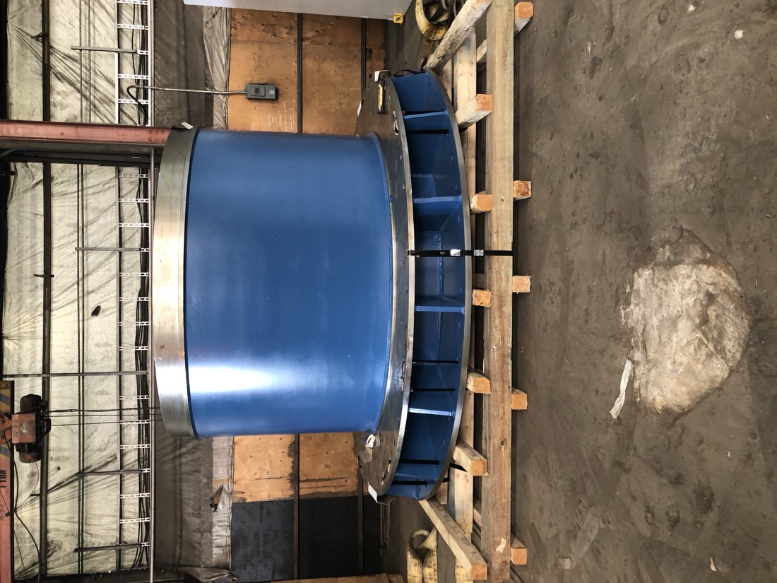 Blue cylindrical vessel / mixer tank on wooden cribbing in warehouse