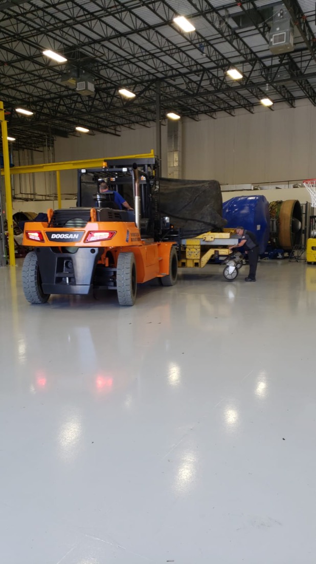 Doosan forklift moving jet engine on stand at Vortex Aviation MRO facility