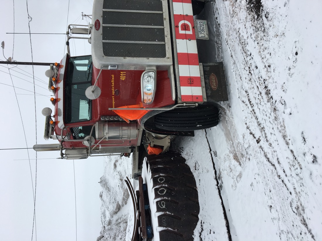 Red Peterbilt heavy-haul tractor (front view) in winter conditions