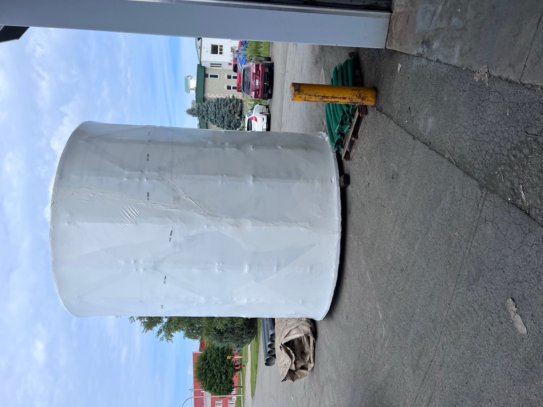 Large shrink-wrapped cylindrical industrial component (tank or vessel) on flatbed