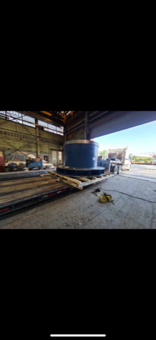 Blue industrial cylindrical component / mill rotor on cribbing inside fab shop