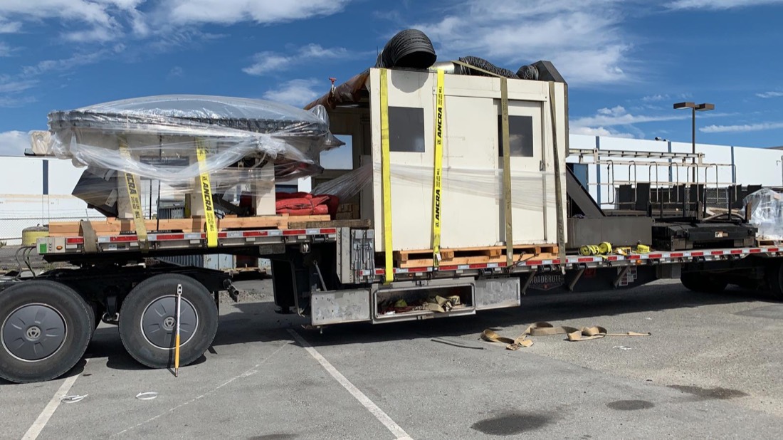 Mori Seiki CNC machining center (cabinet enclosure + machine) on step-deck flatbed