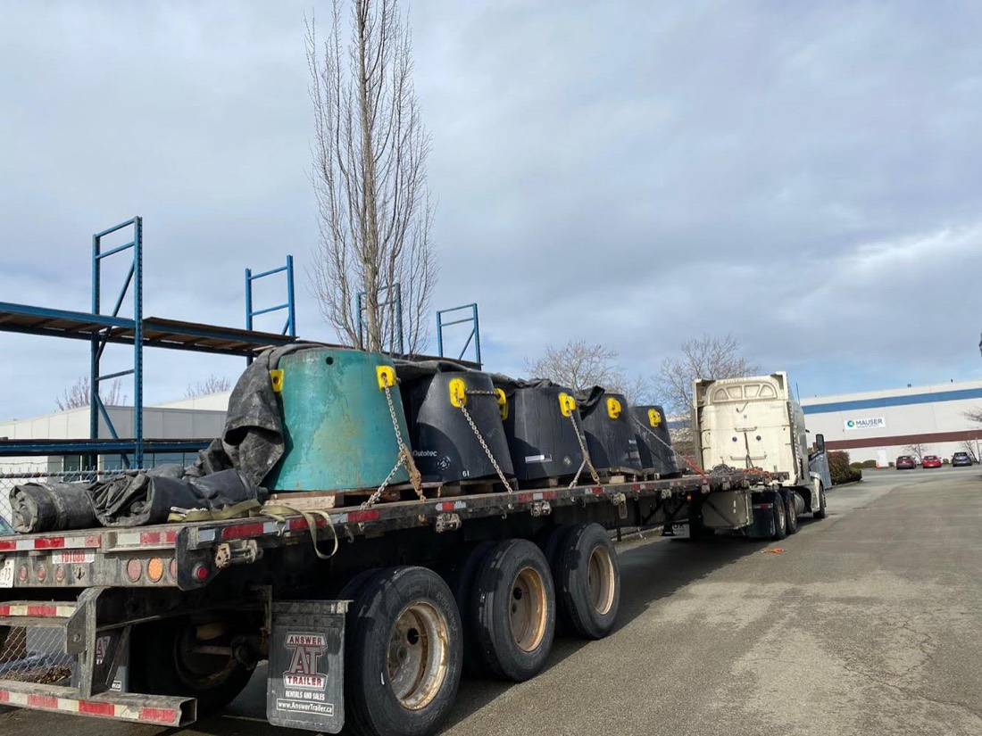 Row of gyratory crusher mantles / mining wear parts chain-secured on tri-axle flatbed