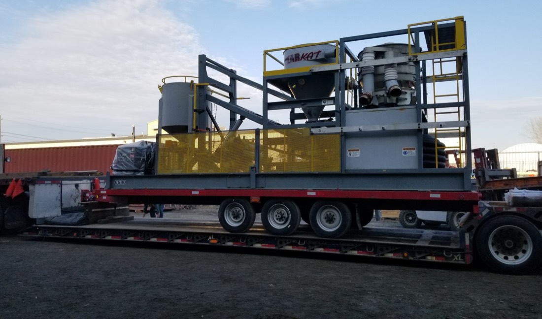 Bear Kat mining processing skid (hopper + cyclones + catwalk) on flatbed trailer