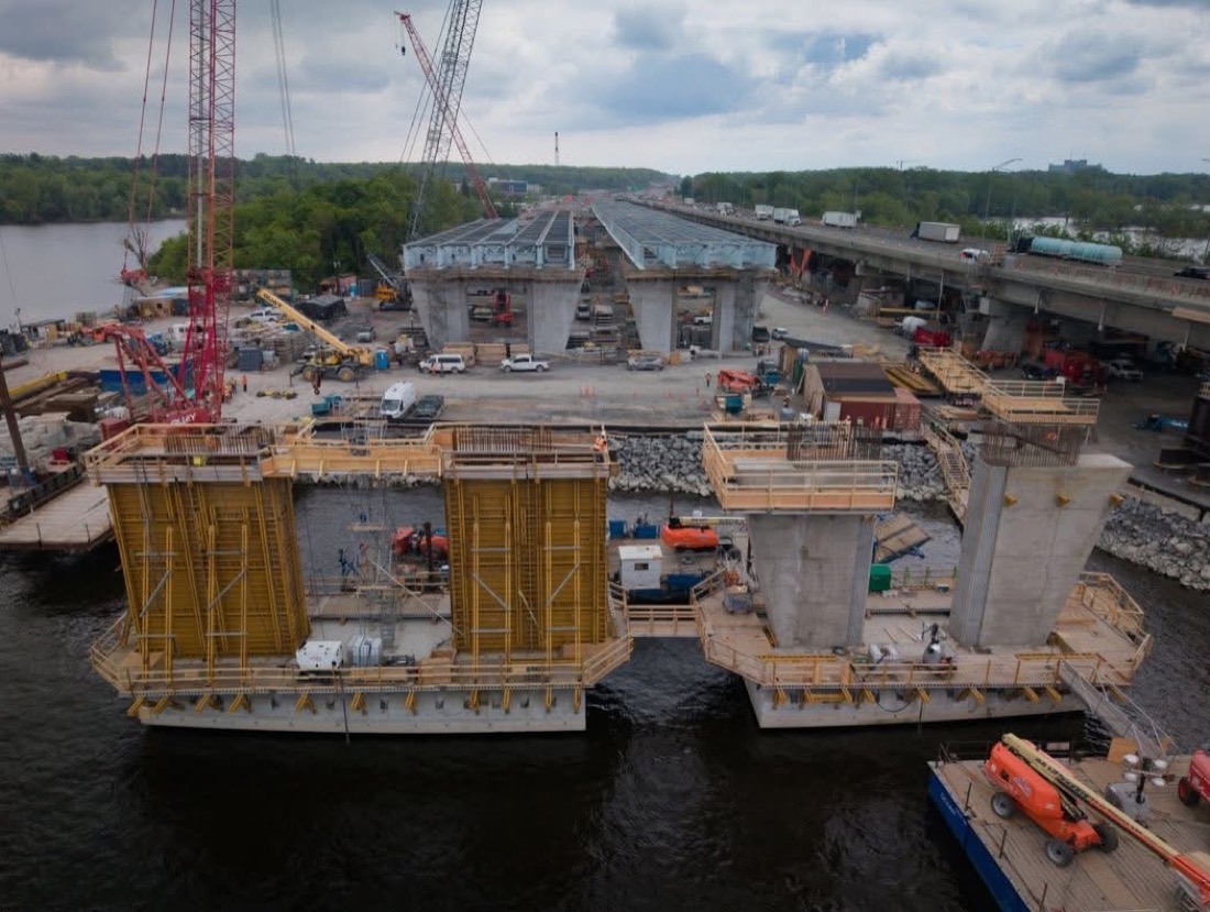 Île-aux-Tourtes bridge concrete piers being formed with yellow formwork, cranes on barges