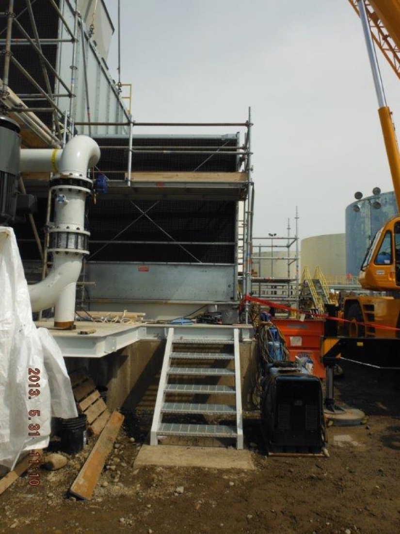 Cooling tower fan stack with scaffolding and crane boom rigging during install