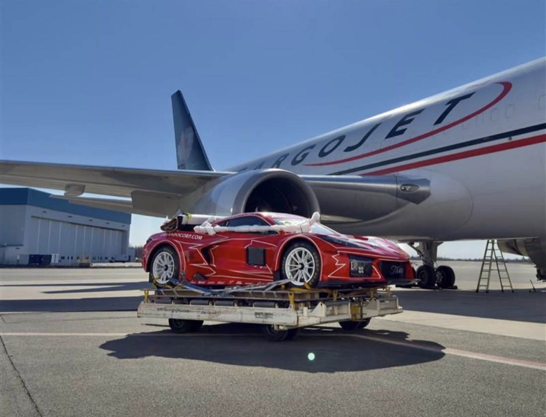 Red Corvette race car on dolly being loaded into CargoJet 767 freighter