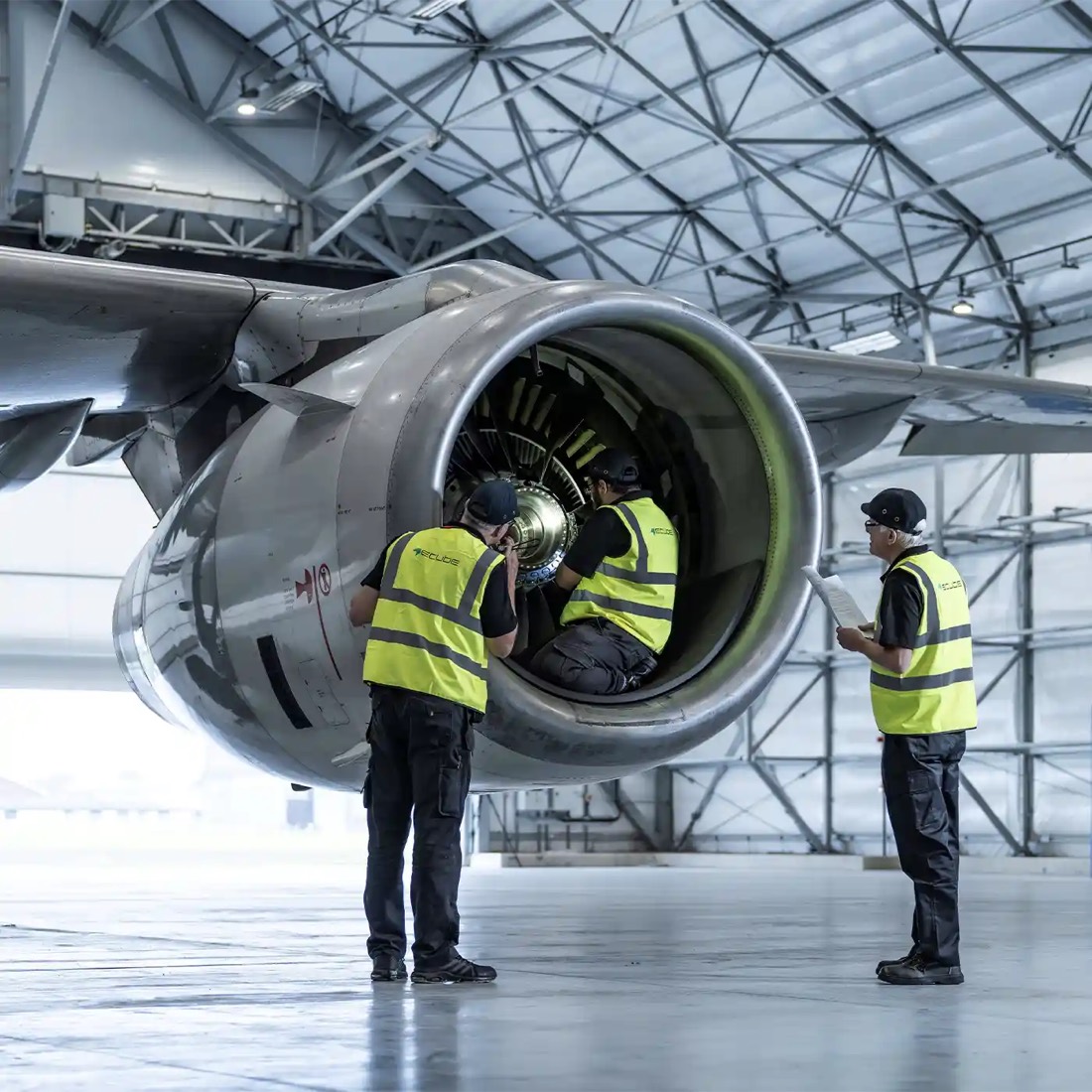 MRO technicians inspecting turbofan engine inlet inside an aircraft hangar — stock illustration