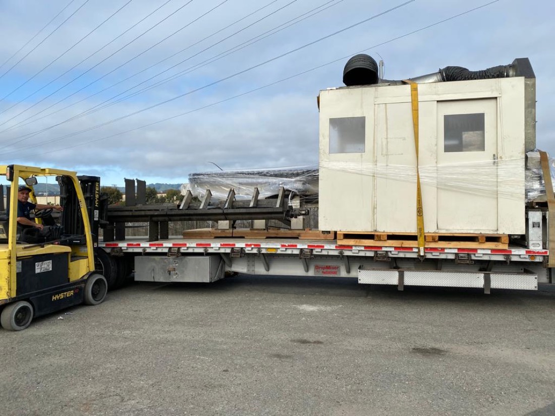 CBS Parts shipment — operator enclosure and conveyor framework on stepdeck, Hyster forklift staging