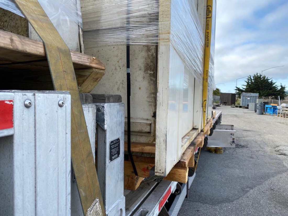 CBS Parts shipment — close-up of strap detail securing crated machinery against ductwork