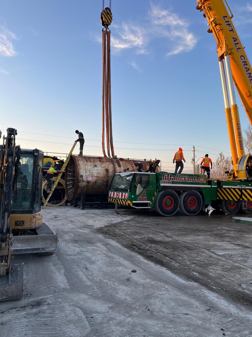 Riggers walking TBM section into position as Lift All Crane outriggers are set