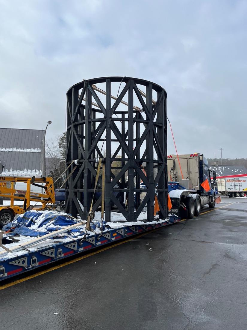 Bare black trommel screen cage on stepdeck, ready for tarp wrap in winter yard