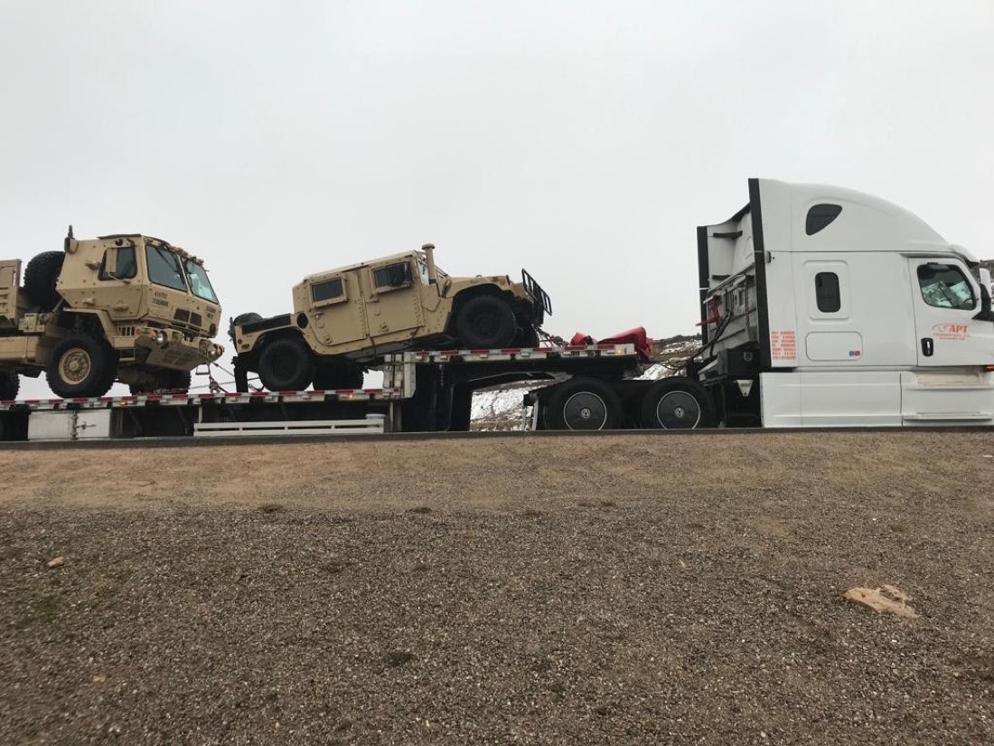 Pair of military Humvees stacked on stepdeck behind day-cab tractor
