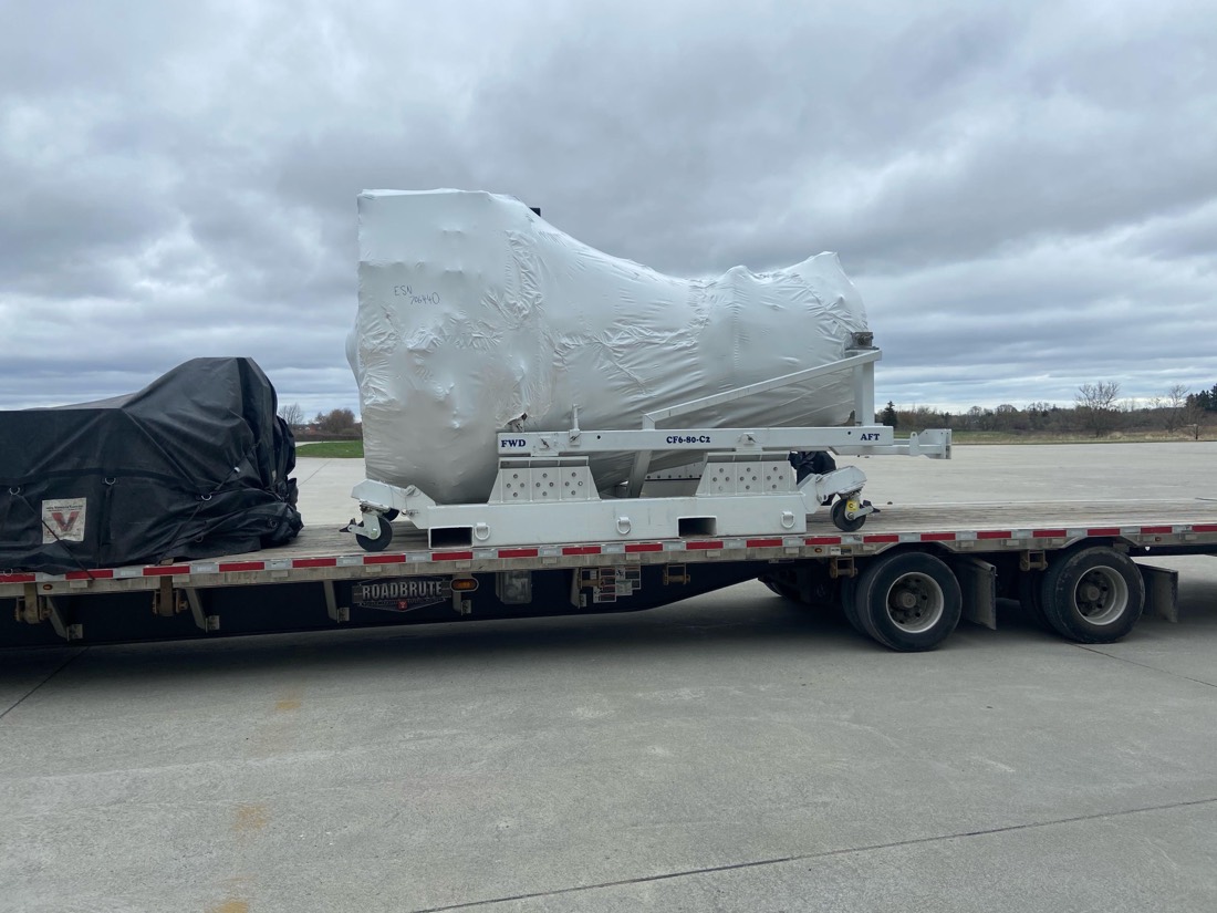 CFM CF6-80-C2 jet engine shrink-wrapped on white aero cradle, Roadbrute lowboy