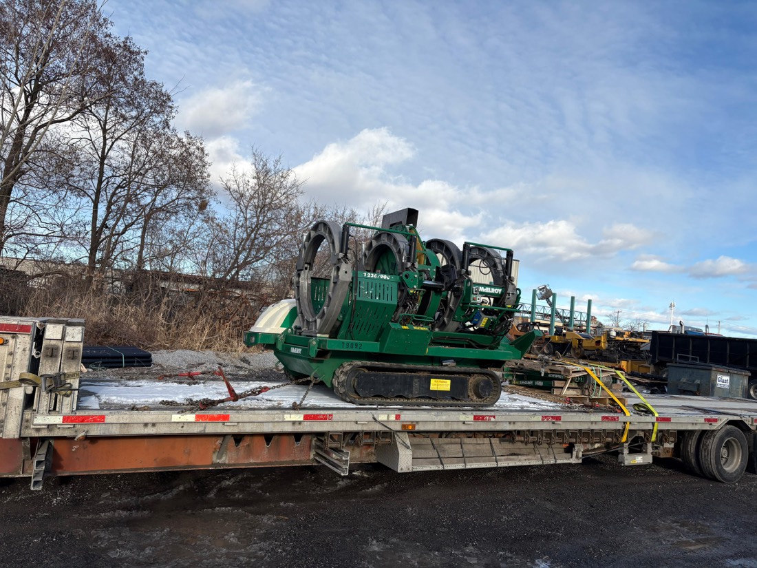 Green Vermeer tracked horizontal directional drill secured on stepdeck at winter site