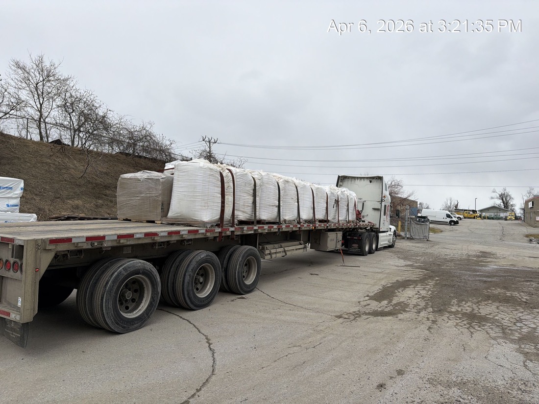 FIBC bulk bag load being secured on tridem flatdeck, pulled out of yard